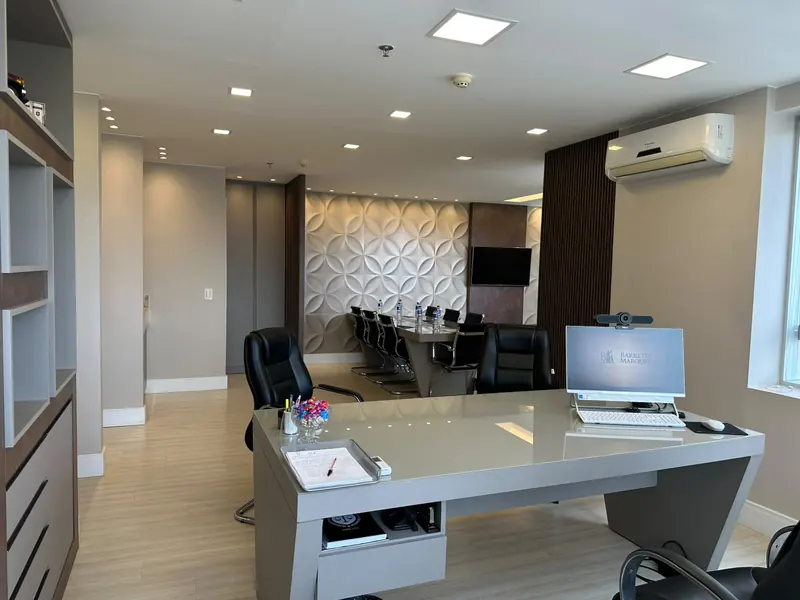 Mesa de trabalho do advogado com a sala de reunião ao fundo